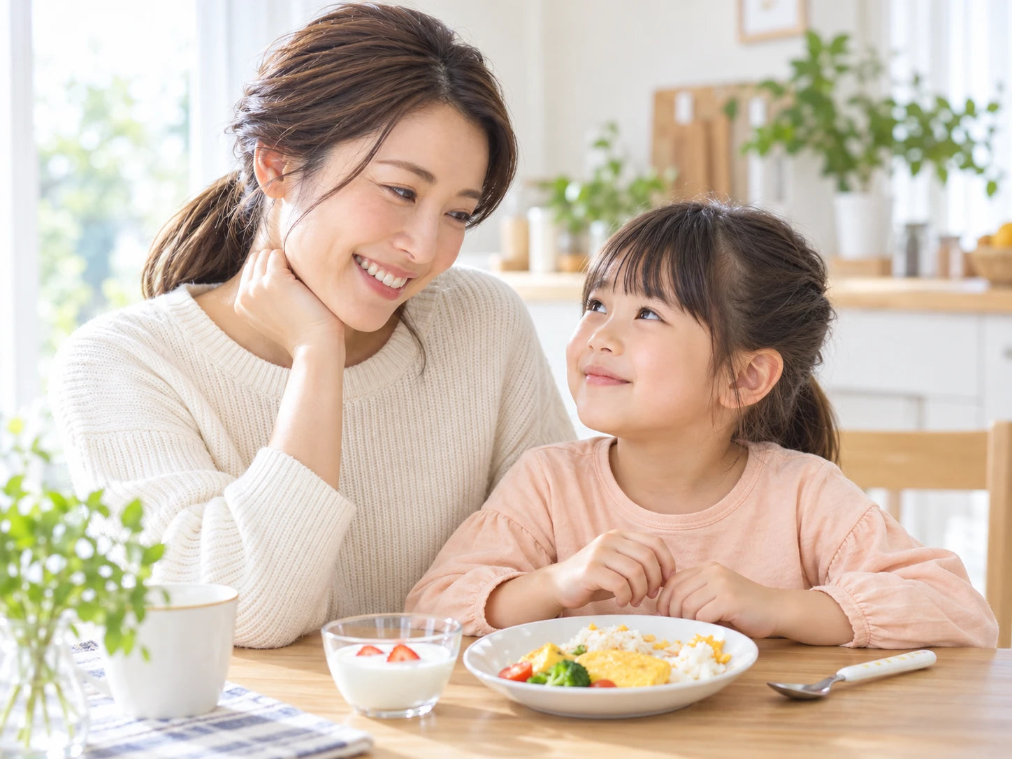 朝の食卓で、穏やかに顔を見合わせる母親と娘のイメージ
